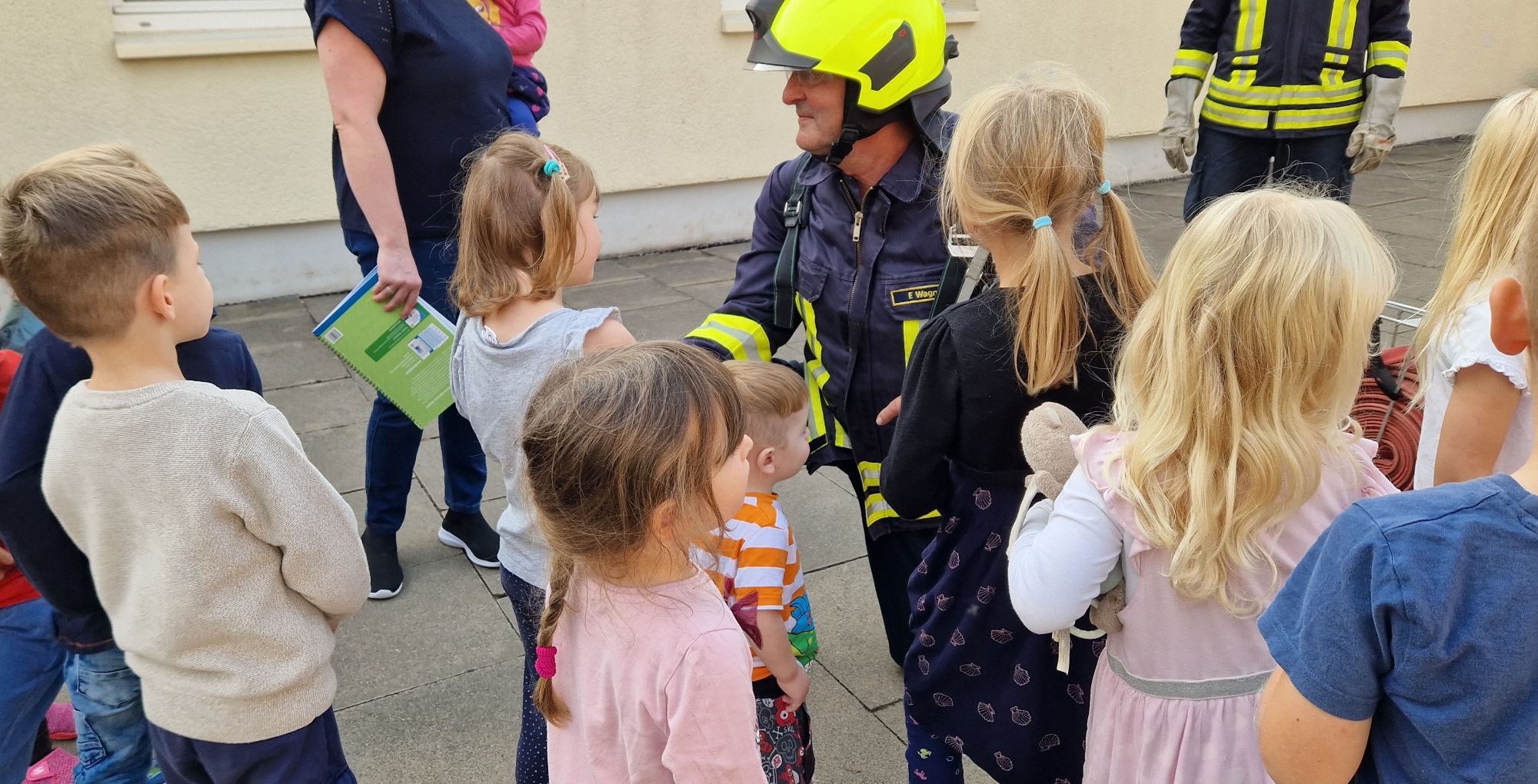 Kamerad "Frank" zeigt den Kindern Ausrüstungsgegenstände